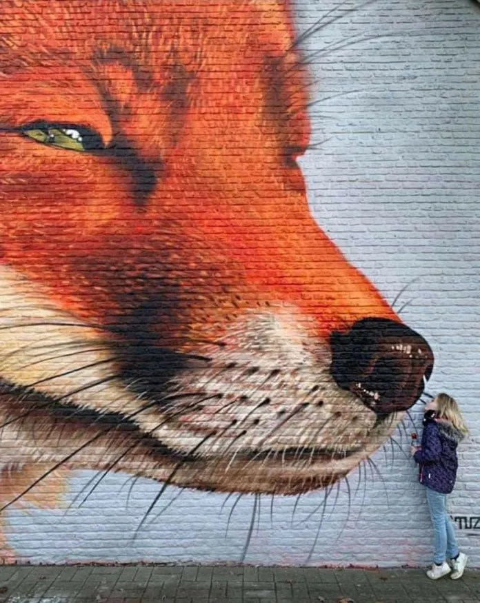 Large fox face mural on a brick wall