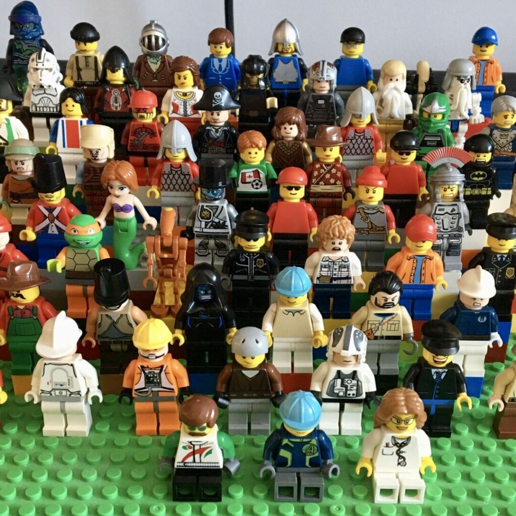 Several dozens of LEGO minifigures assembled from various parts on a brick-built bleachers. Includes parts from pirate, roman, medieval, city, Star Wars and The Lord of the Rings themes.