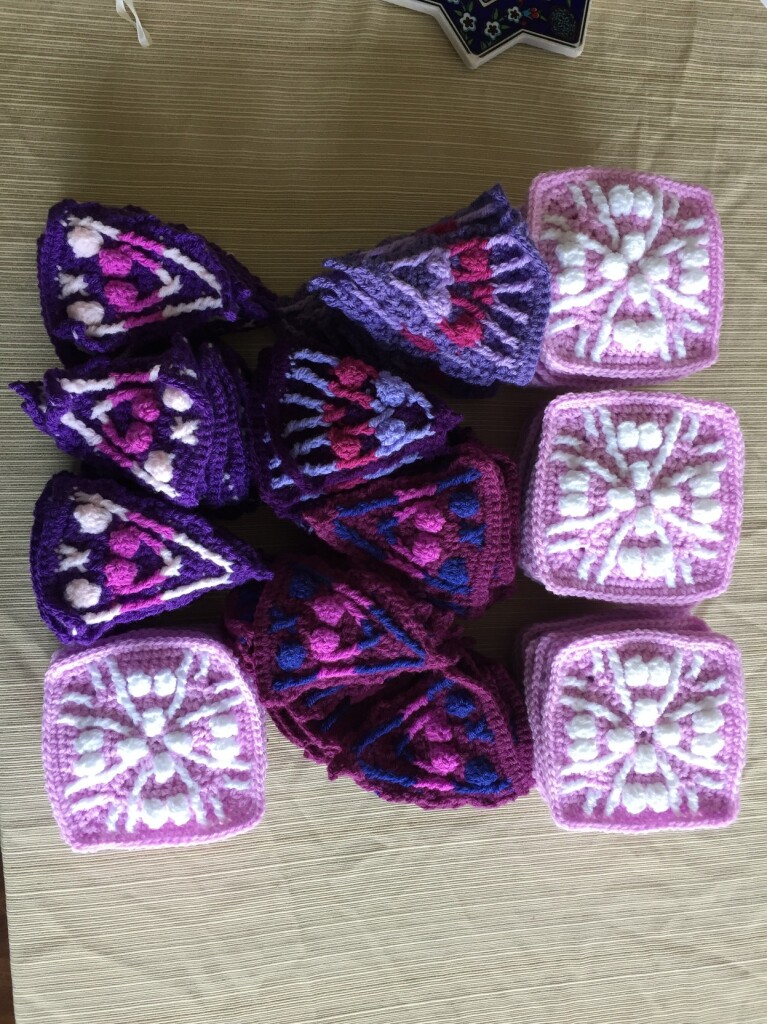 8 piles of crochet triangles in 4 patterns, 4 piles of squares 