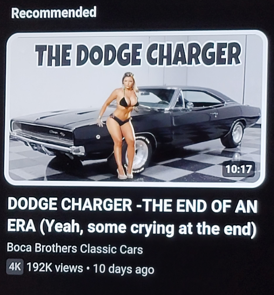 the thumbnail for a recommended video called "dodge charger-the end of an Era (yeah some crying at the end)" with a photo of an old black car on black and white checkered tile and with a very buxom woman wearing only a black bikini top and bottom leaning seductively against the car. 