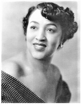 Photograph of Mary Kenner, a smiling Black woman with neatly-curled hair and an off-the-shoulder dress.