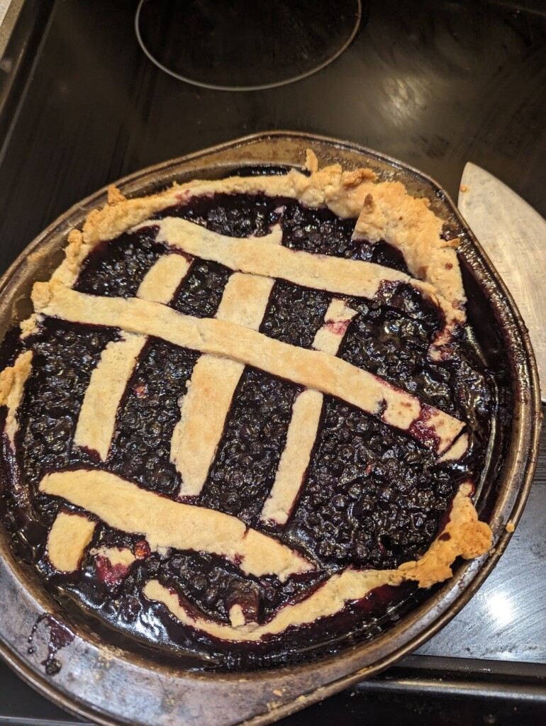 A wild berry pie with wildly asymmetrical lattice work. 