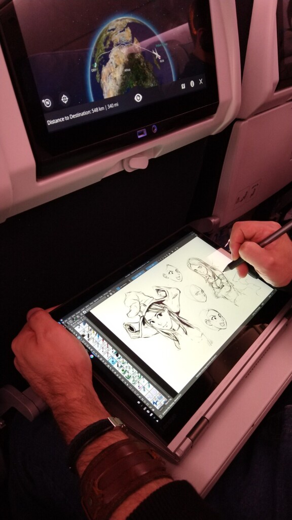 View on my hands, while drawing on the display screen of a Lenovo Thinkpad Yoga 370, with a Wacom Bamboo stylus. The sketch are: 3 unfinished expression, a drawing of Pepper and another in progress. The interactive screen in the seat of the plane show a flight from France to Reunion , an Island near Madagascar.