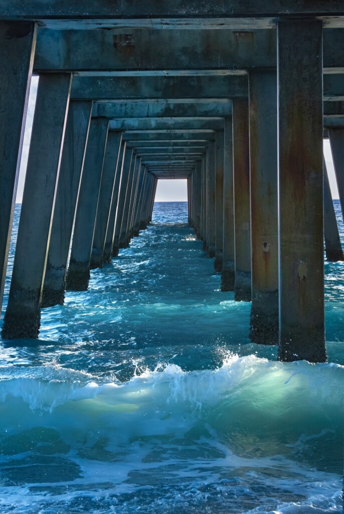 Under the Juno Pier on the beautiful Atlantic coast of Florida. Deep blue waves crashing under the pier 