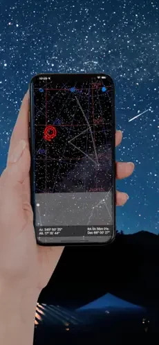 A hand holding a phone with the Comet Nishimura app running and showing the location of the comet. In the background a horizon and the night sky are visible. 