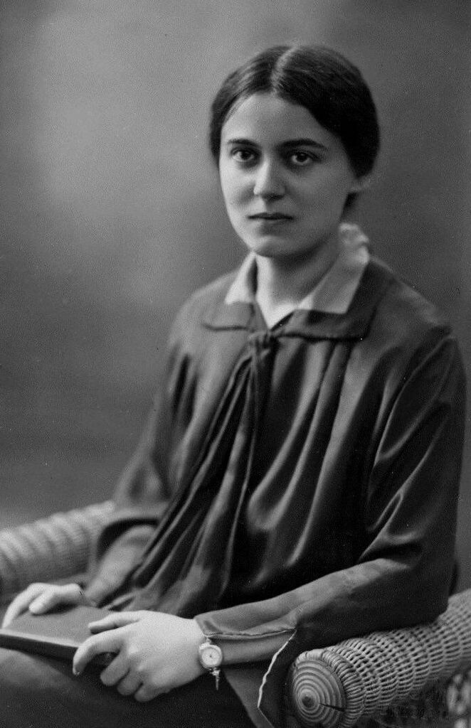 A photo of Edith Stein sitting in an arm chair and holind a book.