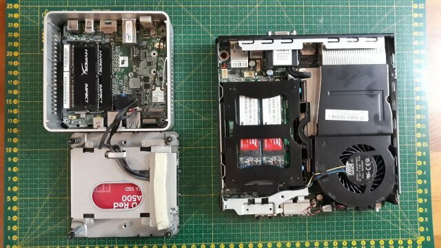 Na stole leżą , ze zdjędą pokrywą obudowy, dwa komputery: Intel NUC oraz Lenovo ThinkCentre