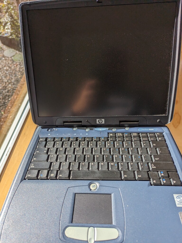 a heavy old blueish clunker laptop.