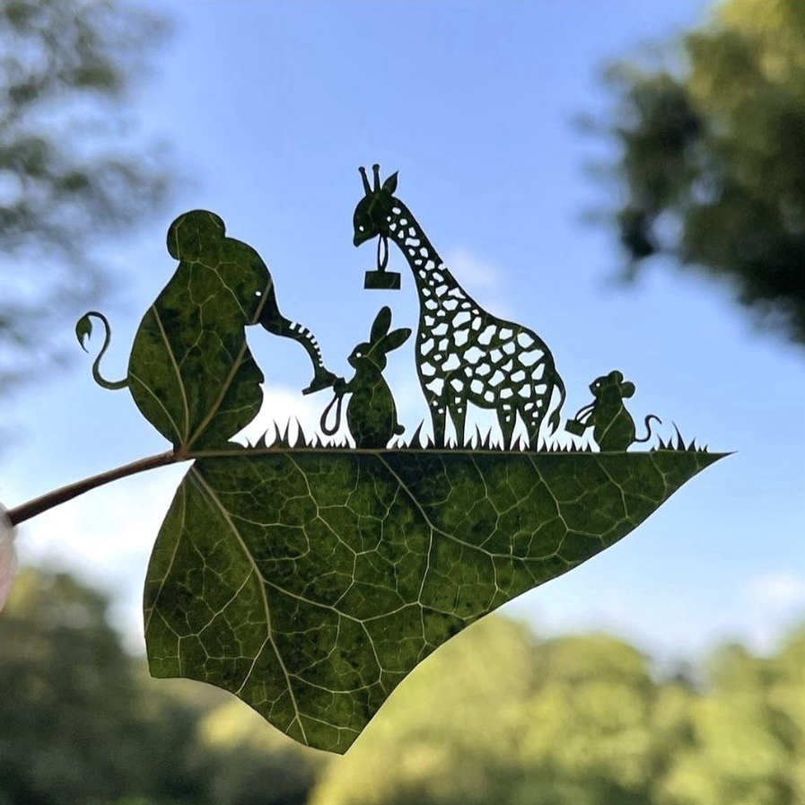 Cut out leaf with a rabbit, giraffe & mouse. It looks like they are queuing in front of the elephant with tickets in their hands, ready to enter.