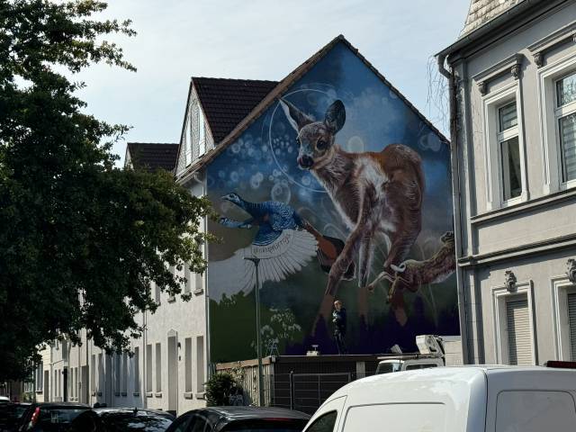 Ein Mural an einer Häuserwand in Entstehung.