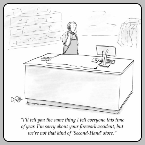 The image is a black and white cartoon depicting a scene inside a store. A person is standing behind a large desk, wearing an apron, and talking on a phone. The desk is equipped with a computer monitor, a keyboard, and a telephone. The background shows shelves with various items, suggesting a retail environment. The person appears to be responding to a customer's inquiry, as indicated by the speech bubble at the bottom of the image. The text in the speech bubble reads: "I'll tell you the same thing I tell everyone this time of year. I'm sorry about your firework accident, but we're not that kind of 'Second-Hand' store." The cartoon humorously addresses a customer's request for second-hand fireworks, implying that the store does not sell such items.