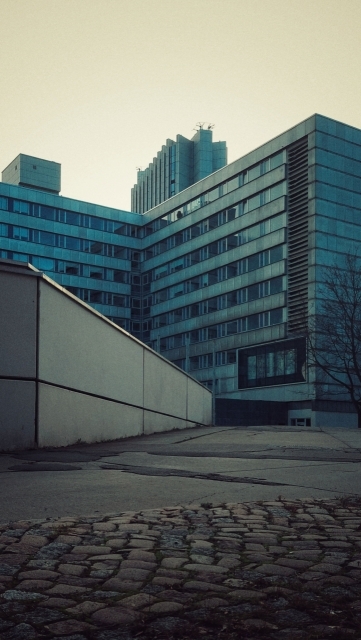 East modernist high-rise. A concrete driveway in front.
