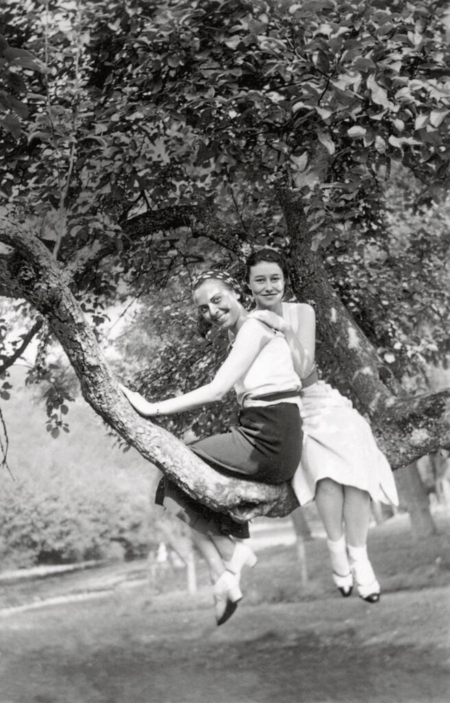 a black-and-white snapshot of a woman in a tree