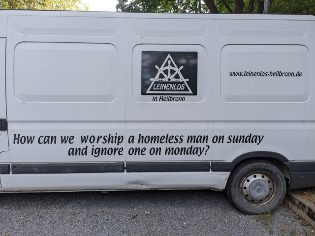 Auf die Seitenwand eines geparkten, schon etwas zerschrammten und in die Jahre gekommenen Transporters ist ein bekannter Satz von Shane Claiborne aufgebracht: „How can we worship a homeless man on sunday and ignore one on monday?“