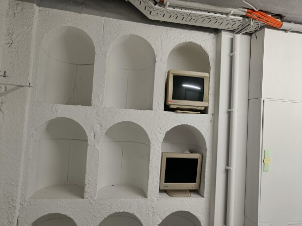 brick alcoves on the wall with old beige crt monitors 