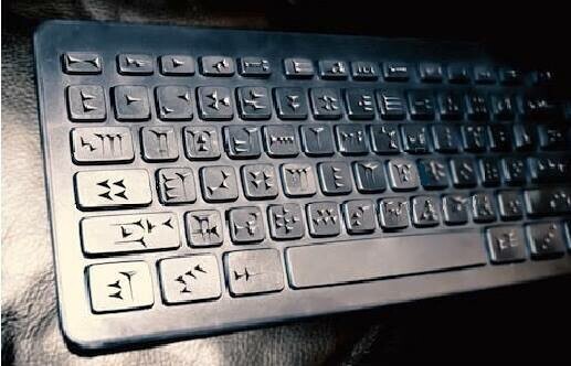 A black monochromatic keyboard custom made to have cuneiform symbols on all of the keys instead of letters of the alphabet.