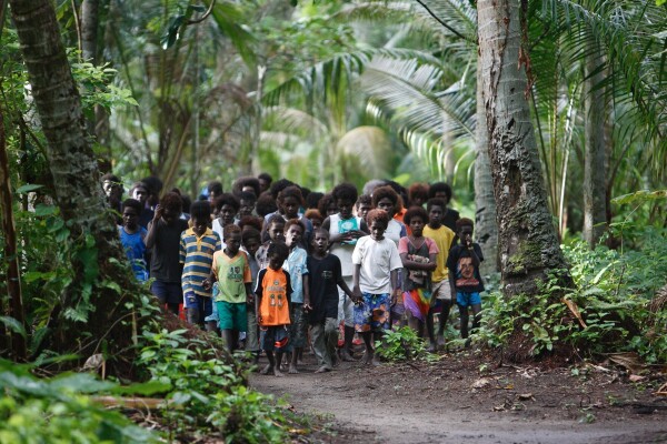 The Climate Refugees of the Carteret Islands in Papua New Guinea.
Children are doing a procession through the woods.