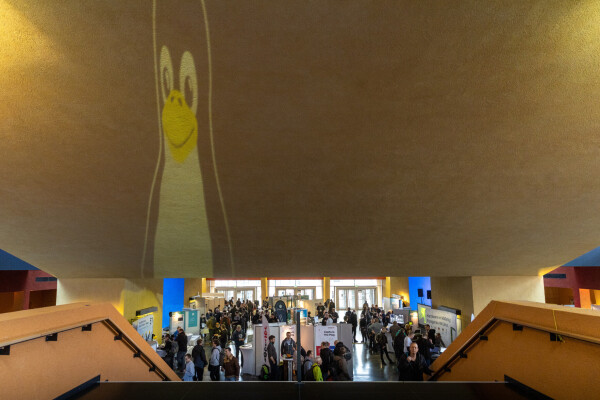 ein blick auf die messe von der treppe, mit dem projezierten tux logo an der decke