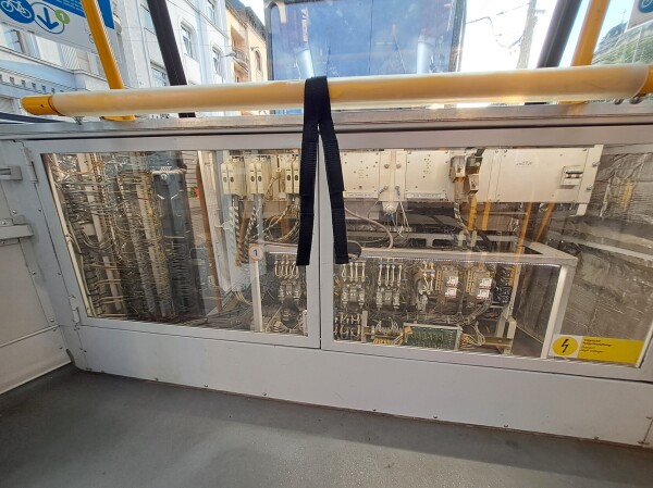 Clear panel inside the tram at floor level. Showing... complicated mechanical and electrical stuff.