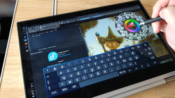 A photo of the Lenovo 370 Yoga device, running Fedora with a digital quick painting of Carrot in Krita done in the train. The keyboard on screen is 'onboard' and the system settings shows the Fedora logo. A terminal windows has 'Hello World!' written on it.