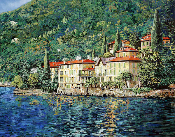 Painting of the village Bellano at Lake Como in Italy. The lake is below in the paintings and is dark blue with hints of green, turquoise and yellow in it. On the shore are a couple of big light brown houses with orange roofs. Around them and in between them are green trees. Behind the village is a hill, covered with trees in various shades of green and some blue.