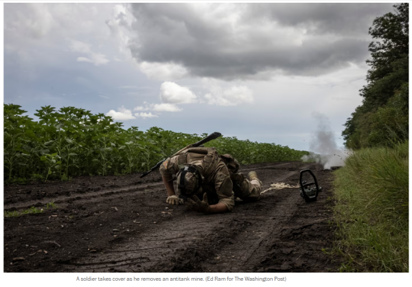 Photo: A soldier takes cover as he removes an antitank mine. (Ed Ram for The Washington Post)