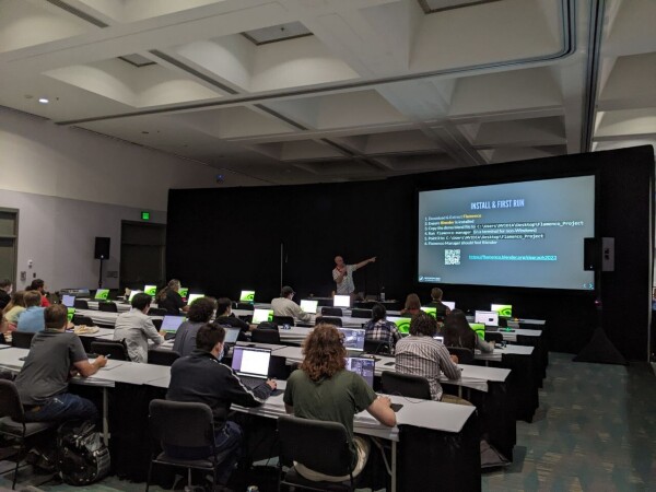 Rows of people behind laptops. Me in the background pointing at a slide presenting Flamenco.