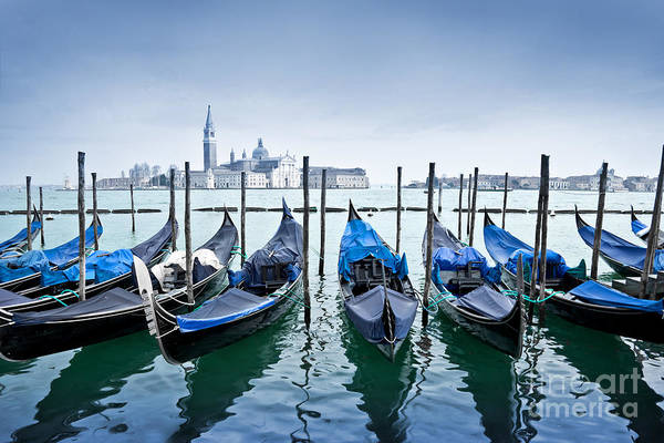 Gondolas near Saint Mark square, San Giorgio Maggiore in the background in Venice, Italy. Travel photography by Delphimages.