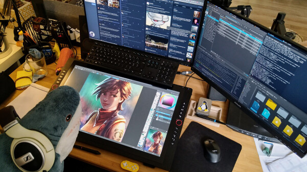 A photo of my desk with three monitors; one on the desk is a pen display tablet (a Xppen Artist Pro 24) with customised shortcut written in white using nail polish. The tablet has a keyboard using a CinTweak keyboard holder. The keyboard is the classic flat from Dell. I have also a little bluetooth gamepad with key customised (by 8bitdo). On the foreground, a Blahaj shark plushies is wearing headphones. On the canvas, a study I made two weeks ago and on other monitors Mastodon in multi column 'deck' mode. Same, two weeks ago when I took this shot. The last monitor has Dolphin the file explorer of KDE Plasma Fedora, IRC, Clementine to listen musique.  A terminal windows is around, I was updating the monitor calibration with argyllcms using command line interface. 