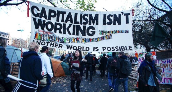 Banner at a protest rally says: "Capitalism isn't working. Another world is possible."