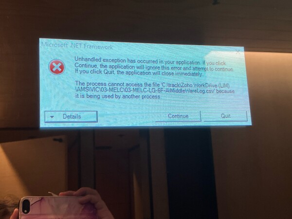 A mirror in a public restroom with a digital overlay showing a windows error message 