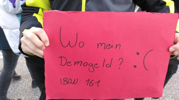 Schild: "Wo bleibt mein Demogeld?"