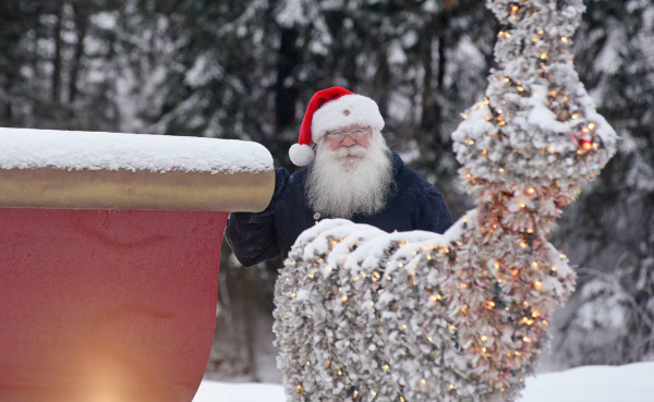 Santa Claus standing behind a reindeer in North Pole, Alaska. Yes, his legal name is Santa Claus.