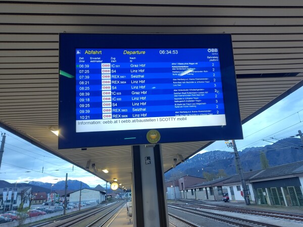 Bildschirm am Bahnsteig mit Zugabfahrten. Der nächste Zug fährt nach Graz.