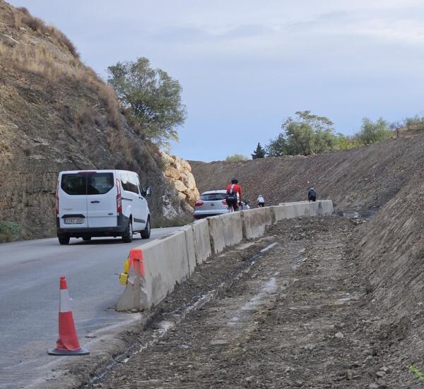 photo of a road with no sidewalks. on one side there seems to be a small amount of progress towards building a sidewalk.