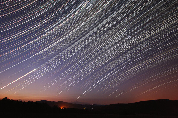 2007 December 8

Star Trails at Dawn
 * Credit & Copyright: Koen van Gorp

Explanation: 
Just fix your camera to a tripod and you too can make an image of graceful trails traced by the stars as planet Earth rotates on its axis. Made on September 14 from Montlaux, France, this wide-angle view nicely shows the stars near the celestial equator tracing nearly straight lines in projection, while stars north and south of the equator, respectively, appear to circle the north and south celestial poles. Featured are the stars of Orion (right of center), brilliant Venus rising (left) as bright star Sirius rises in the south (bottom center), and a polar orbiting Iridium satellite (upper left). Beautiful dawn sky colors seem painted along the horizon. This remarkable picture was constructed from 477 consecutive 30 second digital exposures recorded over 4.3 hours and later combined. 

Authors & editors: Robert Nemiroff (MTU) & Jerry Bonnell (UMCP)
NASA Official: Phillip Newman Specific rights apply.
NASA Web Privacy Policy and Important Notices
A service of: ASD at NASA / GSFC
& Michigan Tech. U.