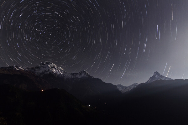 2009 November 28

Annapurna Star Trails
 * Credit & Copyright: Wang Jinglei, Jia Hao

Explanation: In myth, Atlas holds up the heavens. But in this moonlit mountainscape, peaks of the Himalayan Annapurna Range appear to prop up the sky as seen from Ghandruk, Nepal. From left to right the three main peaks are Annapurna South (7,219 meters), Hiunchuli (6,441 meters), and Machapuchare (6,995 meters). Of course the mountains are moving not the stars, the Earth's rotation about its axis causing the concentric star trails recorded in the time exposure. Positioned above Annapurna South, the North Celestial Pole is easily identified as the point at the center of all the star trail arcs. The star Polaris, also known as the North Star, made the very short and bright arc closest to the North Celestial Pole. 

Authors & editors: Robert Nemiroff (MTU) & Jerry Bonnell (UMCP)
NASA Official: Phillip Newman Specific rights apply.
NASA Web Privacy Policy and Important Notices
A service of: ASD at NASA / GSFC
& Michigan Tech. U.