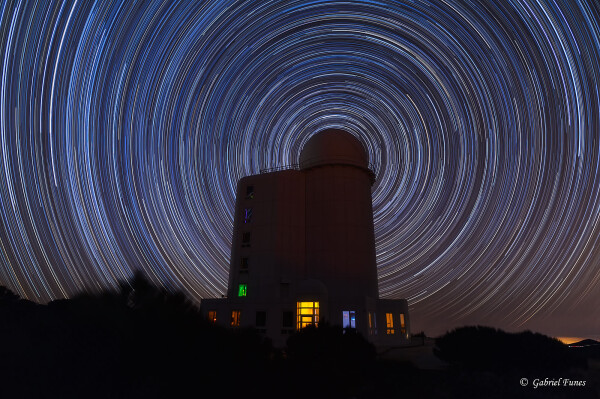 2019 January 18

Circumpolar Star Trails
Image Credit & Copyright: Gabriel Funes

Explanation: 
As Earth spins on its axis, the stars appear to rotate around an observatory in this well-composed image from the Canary Island of Tenerife. Of course, the colorful concentric arcs traced out by the stars are really centered on the planet's North Celestial Pole. Convenient for northern hemisphere astro-imagers and celestial navigators alike, bright star Polaris is near the pole and positioned in this scene to be behind the telescope dome. Made with a camera fixed to a tripod, the series of over 200 stacked digital exposures spanned about 4 hours. The observatory was not operating on that clear, dark night, but that's not surprising. The dome houses the Teide Observatory's large THEMIS Solar Telescope. 

Authors & editors: Robert Nemiroff (MTU) & Jerry Bonnell (UMCP)
NASA Official: Phillip Newman Specific rights apply.
NASA Web Privacy Policy and Important Notices
A service of: ASD at NASA / GSFC
& Michigan Tech. U.