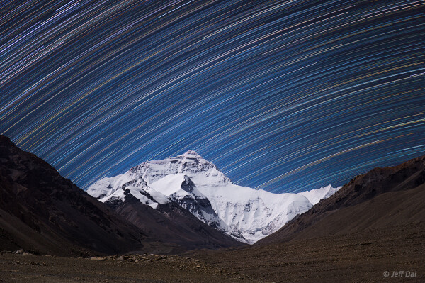 2018 December 1

Mount Everest Star Trails
 * Image Credit & Copyright: Jeff Dai (TWAN)

Explanation: 
The highest peak on planet Earth is framed in this mountain and night skyscape. On September 30, the digital stack of 240 sequential exposures made with a camera fixed to a tripod at an Everest Base Camp captured the sheer north face of the Himalayan mountain and foreground illuminated by bright moonlight. Taken over 1.5 hours, the sequence also recorded colorful star trails. Reflecting the planet's daily rotation on its axis, their motion is along gentle concentric arcs centered on the south celestial pole, a point well below the rugged horizon. The color of the trails actually indicates the temperatures of the stars. Blueish hues are from hotter stars, and yellow to reddish hues are from stars cooler than the Sun. 

Authors & editors: Robert Nemiroff (MTU) & Jerry Bonnell (UMCP)
NASA Official: Phillip Newman Specific rights apply.
NASA Web Privacy Policy and Important Notices
A service of: ASD at NASA / GSFC
& Michigan Tech. U.