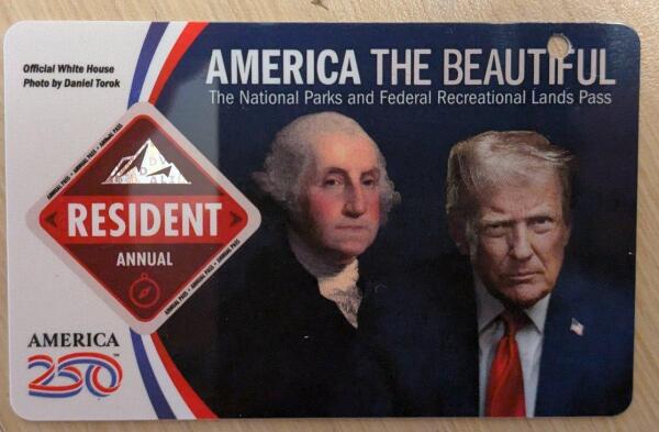 Picture of the front of the annual pass for the American National Park.
On the bottom left there's America 250 but more than half the front is with a picture with the portrait of Washington and a horrible picture of Trump looking ominous with dramatic light on his face wanting to look all tough.
Above there's the text America the beautiful. The National Parks and Federal Recreational Lands Pass.