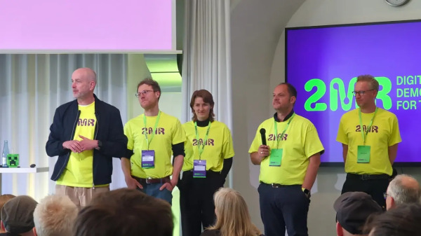 Ein Teil des Teams mit gelben T-Shirts auf der Bühne bei der Verabschiedung